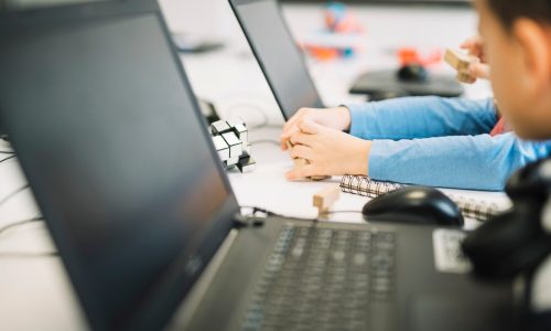 un-bambino-della-ragazza-che-gioca-con-il-cubo-di-legno-puzzle-con-il-computer-portatile-sullo-scrittorio-bianco_23-2148039912